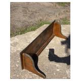 Dark-stained wooden wall shelf with curved side