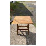 Wood table with a rectangular top and folding leg
