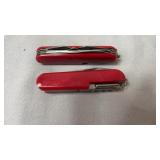 Two red multi-tool pocket knives featuring