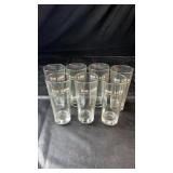 Set of seven clear drinking glasses featuring the