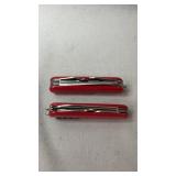 Two red multi-tool pocket knives featuring a