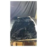 Black throw blanket featuring an attached hood
