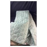 Soft aqua-coloured bedspread featuring an