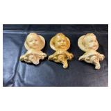 Three chalkware cherub wall plaques with