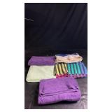 Five bath towels in a mix of purple, light green,
