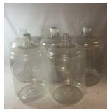 Five large clear plastic carboys for home