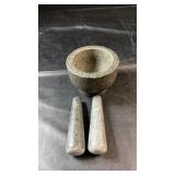 Heavy stone mortar accompanied by two matching
