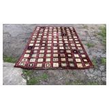 Large rectangular area rug featuring a burgundy
