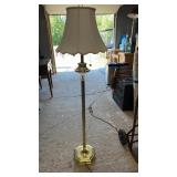 Tall brass-tone floor lamp featuring decorative