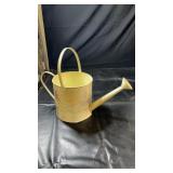 Cream-coloured metal watering can with long