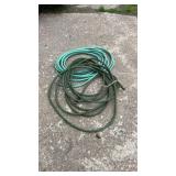 Two coiled garden hoses in green tones with hose