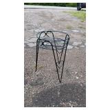 Black metal plant stand with a round open top and