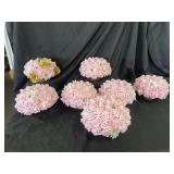 Seven pink and gold and white table arrangements.