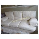 off white leather sofa w pillows throws