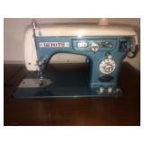 White sewing machine in cabinet