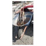 Metal wheelbarrow,  post hole digger, and saws