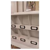 White metal display cabinet with black label