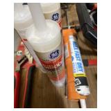Caulk gun with three unopened silicone tubes