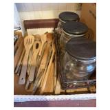 Assorted wooden serving spoons and glass canister