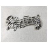 Silver music signs brooch marked Sterling.