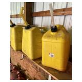 Three yellow diesel fuel cans two of them are 6