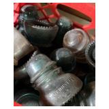 Milk crate full of glass electrical insulators