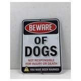 Metal sign stating beware of dogs, not