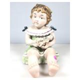 A 12 inch porcelain bisque piano, baby holding a