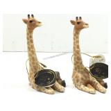 Two small poly, resin sitting giraffe sculptures