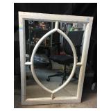A mirror in an antique window frame with oval