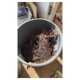 Two trash cans, one 1/4 full of copper wire the
