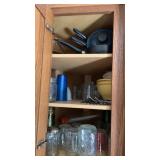 Cupboard of miscellaneous pans , drinking glasses