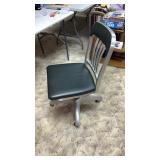Metal office chair on wheels  in basement