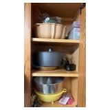 Contents of cabinet: cake pans, strainer and more