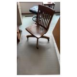 Wooden office chair on wheels and plastic mat