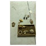 Gold toned jewelry including pins, rings, and