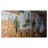 Wall of brooms , mops , lawn chairs and more