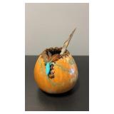Handcrafted decorative gourd art with a turquoise