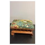 Wooden footstool featuring a colorful tapestry