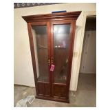 Tall wooden glass-front gun cabinet