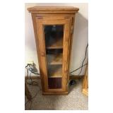 Small wooden cabinet with glass door.