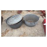 Two large gray granite pans with wooden handles.