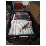 Black plastic crate of towels and linens