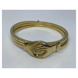 Les Bernard Gold-Tone Clasped Hand Bracelet