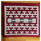 RED AND WHITE WOVEN MAT WITH NAVAJO-STYLE DESIGN