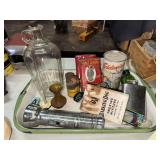 Old tobacco tins, boxes, flashlight, bottles in