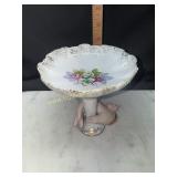 Left on China pedestal holding hand dish