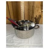 Stock pot with kitchen utensils and measuring