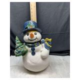 Ceramic snowman figurine holding tree