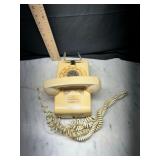 beige rotary desk phone with coiled cord